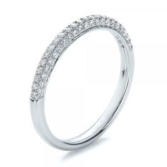 a white gold wedding band with rows of diamonds on the top and bottom half of it