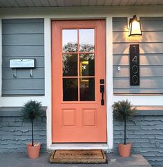 an orange front door on a gray house