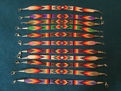 six beaded bracelets are lined up on a blue surface