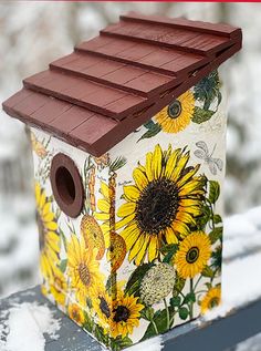 a bird house with sunflowers painted on it