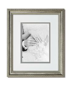 a white and silver frame holds a black and white image of two hands holding each other