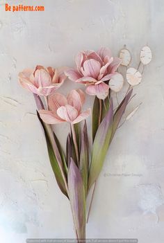 some pink flowers are in a vase on the wall