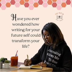 a woman sitting at a table writing on a book with a pen and notebook in front of her