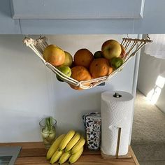 a basket filled with fruit sitting on top of a wooden table next to a toilet