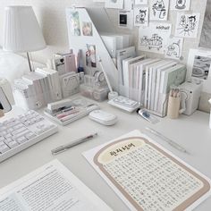 there is a desk with many books and other items on it, including a keyboard