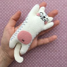 a hand is holding a small stuffed animal