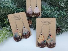 three pairs of earrings with trees on them