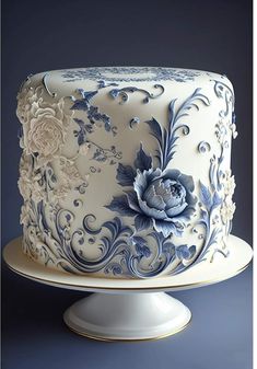 a white and blue decorated cake sitting on top of a table