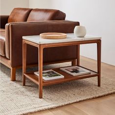 a coffee table sitting on top of a wooden floor next to a brown leather couch