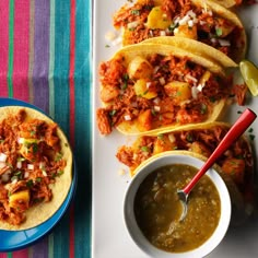 three tacos on a plate next to a bowl of salsa