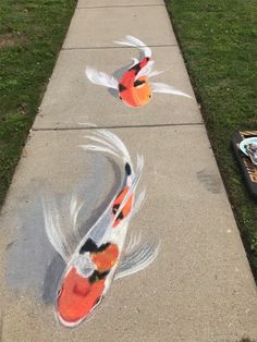 two orange and white fish painted on sidewalk