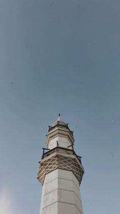 a tall white tower sitting under a blue sky