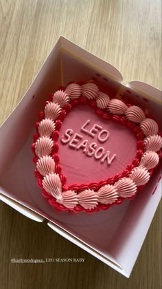 a heart shaped cake with the words leo season written in frosting on top of it