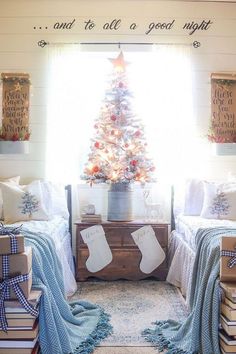 a christmas tree is in the corner of a room with two twin beds and presents