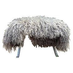 a sheep foot rest made out of fake fur and metal legs on an isolated white background