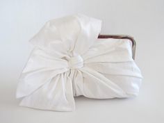 "An original Lost in Time design made in white with powder blue lining. This stunning clutch is labour intensive to create. The bow section of the clutch is three separate pieces, machine and hand sewn to create a full bodied look. The resulting clutch is elegant and creates a substantial \"feel\" in your hand. This clutch must be seen to be fully appreciated. You may choose a different colour for your clutch and lining from the colour chart options. You may choose silver or antique brass for yo Bridal Clutch Purse, Wedding Clutch Purse, Bow Purse, Bow Clutch, Bridesmaid Clutches, Wedding Bags, White Clutch, Wedding Purse, Wedding Clutch