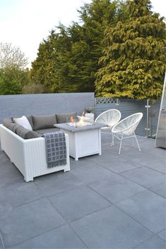 an outdoor living area with white wicker furniture