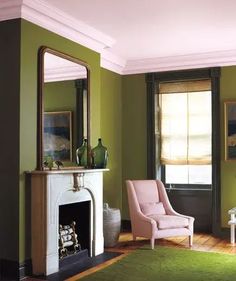 an image of a living room with green walls and white trim on the fireplace mantel