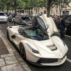 a white sports car is parked on the street