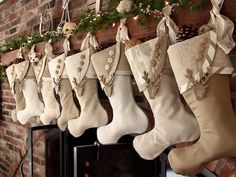 stockings hanging from a mantel decorated with christmas decorations