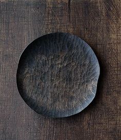 a black plate sitting on top of a wooden table