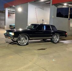 a black car parked in front of a gas station