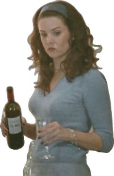 a woman holding a wine glass and bottle