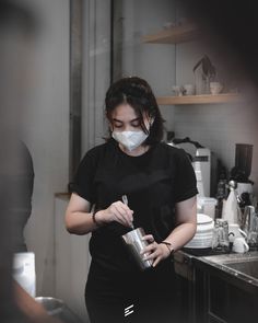 a woman wearing a face mask in the kitchen