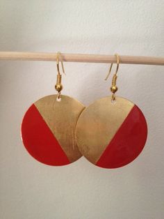 red and gold earrings hanging from a hook