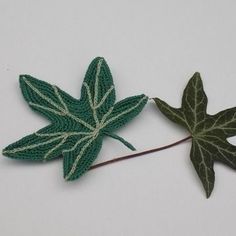 two crocheted leaves sitting next to each other