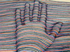 an image of a colorful blanket on the ground with lines drawn across it and in different colors