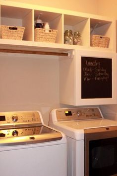 a washer and dryer sitting next to each other in a room with white cabinets