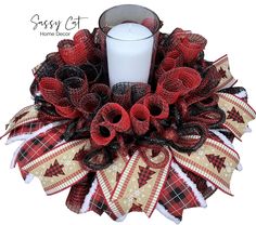 a red and black wreath with a candle