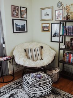 a chair and ottoman in a room with pictures on the wall above it, along with bookshelves