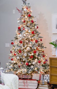 a white christmas tree with red and silver ornaments