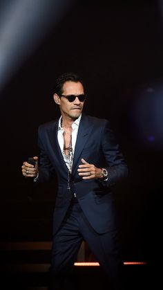 a man in a suit and sunglasses on stage