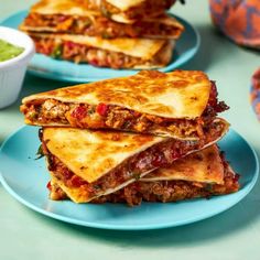 two blue plates with quesadillas stacked on top of each other