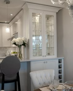 a dining room table with two chairs and a china cabinet