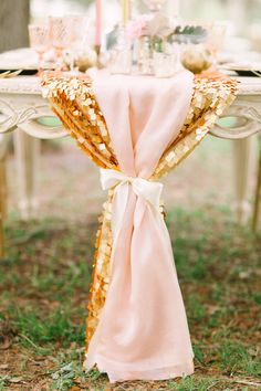 a table with a pink cloth draped over it and some candles on top of it