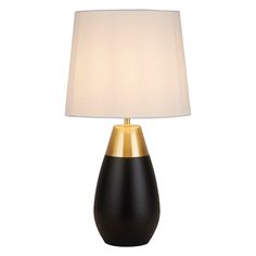 a black and gold table lamp with a white shade on the top, against a white background