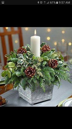 a christmas centerpiece with pine cones and greenery