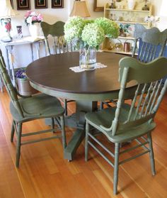 a dining room table with chairs and vases on top of it in front of a fireplace