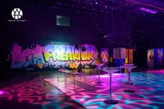 a room with neon lights and graffiti on the walls