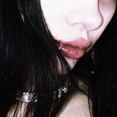 a close up of a person with long black hair and glitter on her face,