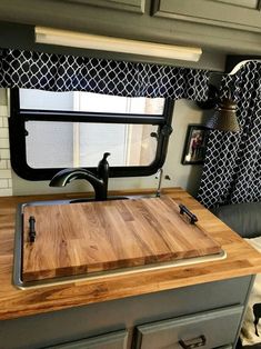 a kitchen with a cutting board on top of it next to a stove and window