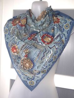 This is a beautiful rich greyish blue scarf with a persian design featuring diamond  pendants and earrings framed in gold and surrounded by red rubies. The scarf is very original and will match your jeans jacket bringing style to your outfit. The scarf is large and can be used as a head scarf too. The scarf was most probably designed and made in Italy, the label is missing. I think that the scarf is polyester, even though it feels like silk. The scarf is in excellent condition. The scarf will al Elegant Multicolor Luxury Scarves, Elegant Handmade Blue Scarves, Abstract Scarf, Luxury Blue Scarf With Floral Print, Luxury Multicolor Square Scarf, Elegant Multicolor Printed Scarf, Purple Silk Scarf, Luxury Artistic Blue Scarves, Jeans Accessories