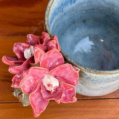 a flower is placed next to a cup on the table