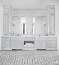 a white bathroom with two sinks and mirrors