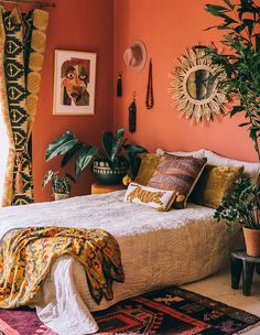 a bedroom with orange walls and plants in the corner