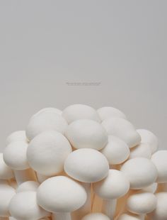 a bunch of white mushrooms sitting on top of each other in front of a gray background